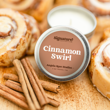 Load image into Gallery viewer, Cinnamon Swirl soy candle in a 4 oz travel tin, from the Signature Collection by Angela Rose Studios, shown with cinnamon sticks and fresh cinnamon rolls.