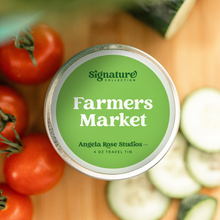 Load image into Gallery viewer, Farmers Market soy candle in a 4 oz travel tin, from the Signature Collection by Angela Rose Studios, shown with fresh tomatoes and sliced cucumbers.