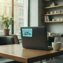 Load image into Gallery viewer, Laptop with a "Let's All Go to the Supper Club" sticker on a wooden table in a cafe setting.